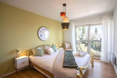 a bedroom with a bed and a large window at L11 Claire Fontaine Sea view 2 BDR AC Parking swiming pool in Nice