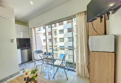 a kitchen with a balcony with a table and chairs at Nestor&Jeeves - PALMA BEACH - Proche Mer in Nice