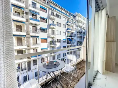 a balcony with a table and chairs in front of a building at Nestor&Jeeves - PALMA BEACH - Proche Mer in Nice