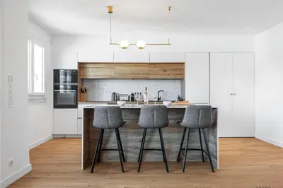 a kitchen with white cabinets and bar stools at Appartement Loulib I Electio in Nice