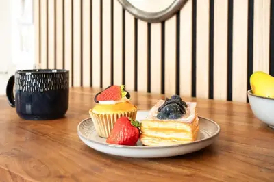 a plate with cakes and strawberries on a table at L46 2P Port, 2min du Cap et 5 du port/ CLIM & WIFI in Nice