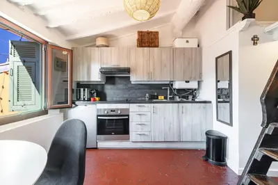a kitchen with wooden cabinets and a red floor at Charming Apartment Old Town in Nice