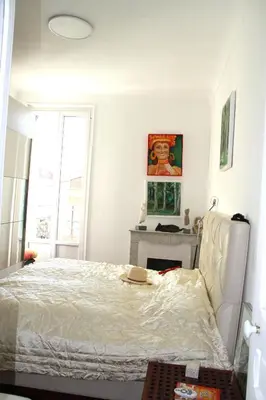 a white bedroom with a bed and a fireplace at APPARTEMENT NICE le PORT in Nice