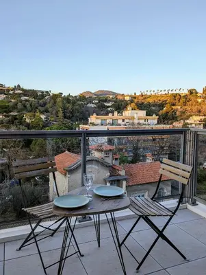 a table and chairs on a balcony with a view at Studio calme avec vue dégagée in Nice
