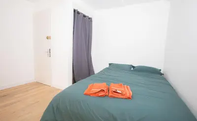 two orange towels sitting on top of a green bed at Cozy studio in Villefranche-sur-Mer in Villefranche-sur-Mer