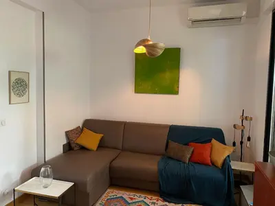 a living room with a couch with colorful pillows at Exceptional Terrace in Center of Nice in Nice