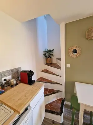 a small kitchen with a staircase in a house at Duplex dans maison de village in Cagnes-sur-Mer