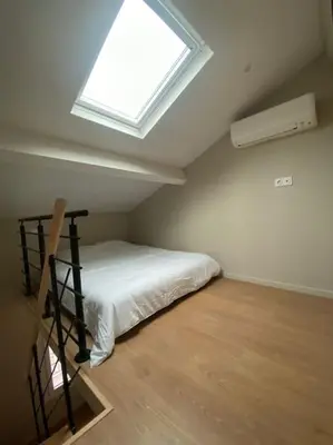 a bedroom with a bed with a window in it at Duplex sur Nice - Libération in Nice