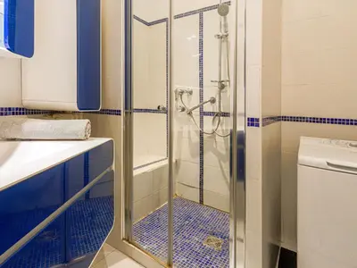 a shower in a bathroom with blue tiles at Apartment Le Victor Hugo by Interhome in Nice