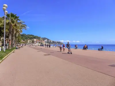 a group of people walking down a sidewalk on the beach at Apartment Le Victor Hugo by Interhome in Nice