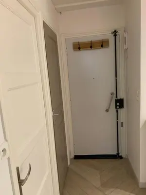 a hallway with a white door and a wooden pole at Charmant Appartement à 5 minutes de la plage in Nice