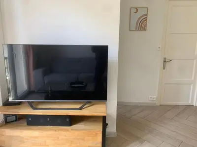 a flat screen tv sitting on top of a table at Charmant Appartement à 5 minutes de la plage in Nice