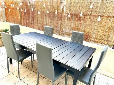 a wooden table with chairs and a fence at Saint Philippe - T3 près de la plage in Nice
