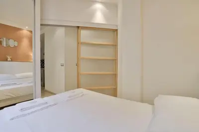 a bedroom with a white bed and a mirror at 12 Trachel - T2 lumineux au coeur de Nice in Nice