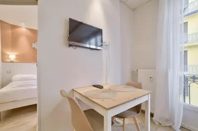 a small room with a table and a tv on a wall at 12 Trachel - T2 lumineux au coeur de Nice in Nice