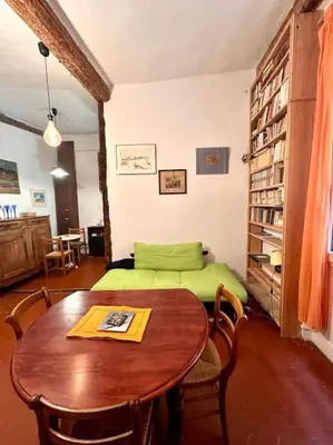 a room with a table and a bed and a table and chairs at Abbaye - Appartement spacieux au coeur du Vieux-Nice in Nice