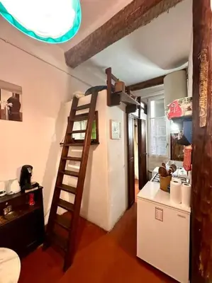 a kitchen with a ladder next to a white refrigerator at Abbaye - Appartement spacieux au coeur du Vieux-Nice in Nice