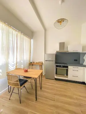 a living room with a table and a kitchen at Alsace Lorraine - Wifi, 3 pers, hyper centre in Nice