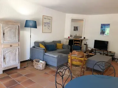 a living room with a blue couch and a tv at Villa de Charme au coeur du Cap-Ferrat in Saint-Jean-Cap-Ferrat