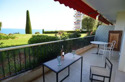 a balcony with a table and two chairs and a bottle of wine at SIRIUS - Exceptionnelle vue mer dans les hauteurs de Nice in Nice