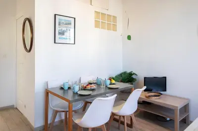 a dining room with a table and white chairs at #21 2 Bdr balconies 10 mins walk to sea 5mins to tram in Nice