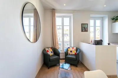 a living room with two chairs and a mirror at #21 2 Bdr balconies 10 mins walk to sea 5mins to tram in Nice