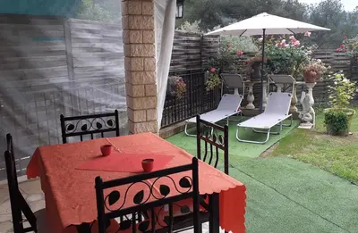 a patio with a table and chairs and an umbrella at Au lit, on dort in Cantaron