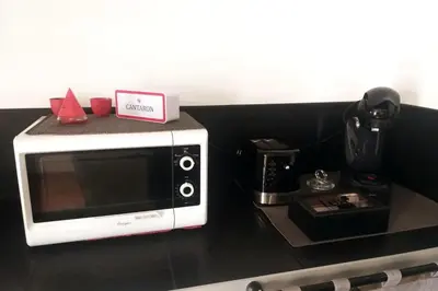 a microwave sitting on top of a counter at Au lit, on dort in Cantaron
