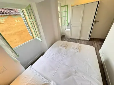 a small bedroom with a bed and a window at Carre D'or: Very Central Calm Cozy 2BR, with Wi-Fi in Nice