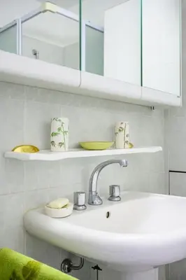 a white bathroom with a sink and a mirror at Nice Absea Belles Terres C in Nice