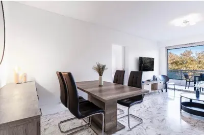 a dining room with a wooden table and chairs at Nice Absea Belles Terres in Nice