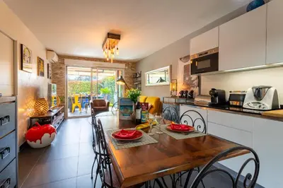a kitchen and dining room with a wooden table at DOMAINE DES ROSES 3 AP4400 By Riviera Holiday Home in Nice