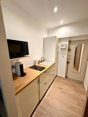 a small kitchen with a sink and a microwave at Rue Droite - Studio cosy au coeur du Vieux-Nice in Nice