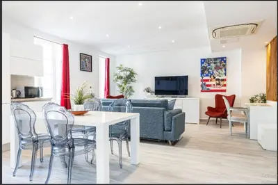 a living room with a table and chairs and a couch at Loft place Masséna avec terrasse in Nice