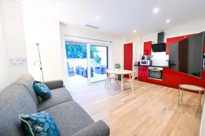 a living room with a couch and a table and a kitchen at Beau studio cozy centre ville et plages avec terrasse n3 in Nice