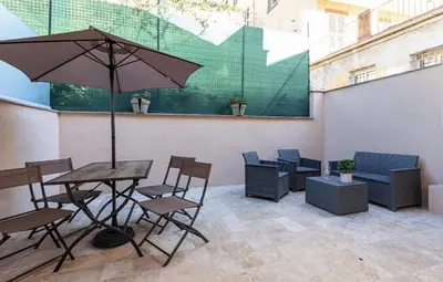 a patio with a table and chairs and an umbrella at Beau studio cozy centre ville et plages avec terrasse n3 in Nice