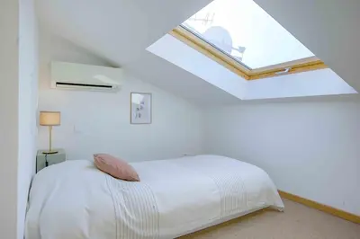 a white bedroom with a bed with a window at Maison Bianchi - 27 Lepante in Nice