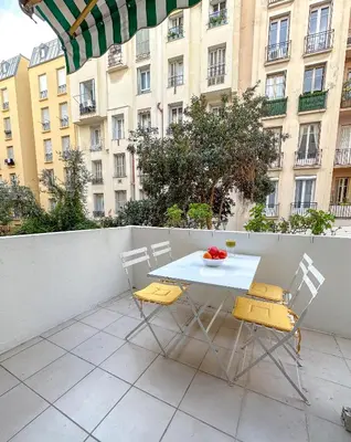 a table and chairs on a balcony with a building at Les Terrasses D'Herold in Nice