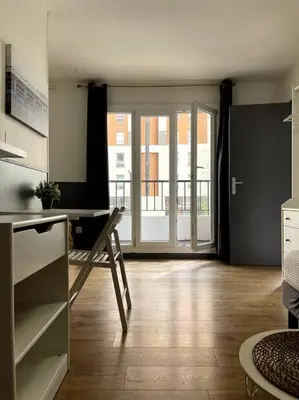 a kitchen with a desk and a door to a balcony at Cosy studio near beaches in Nice