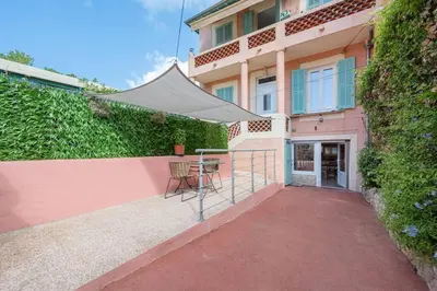 a patio with a table and a tent in front of a building at Charmant 2 pièces au cœur de St Jean Cap Ferrat in Saint-Jean-Cap-Ferrat