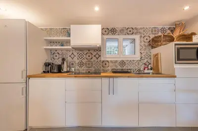 a kitchen with white cabinets and a microwave at Charmant 2 pièces au cœur de St Jean Cap Ferrat in Saint-Jean-Cap-Ferrat