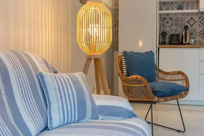 a living room with a couch and a lamp at Charmant 2 pièces au cœur de St Jean Cap Ferrat in Saint-Jean-Cap-Ferrat