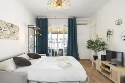 a bedroom with a large bed and a television at Studio Californie FSHH in Nice