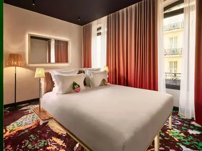 a large white bed in a room with a window at Mama Shelter Nice in Nice