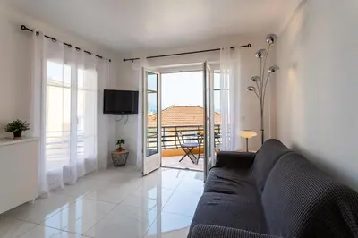 a living room with a couch and a balcony at Cap Ferrat View III AP4401 By Riviera Holiday Hom in Saint-Jean-Cap-Ferrat