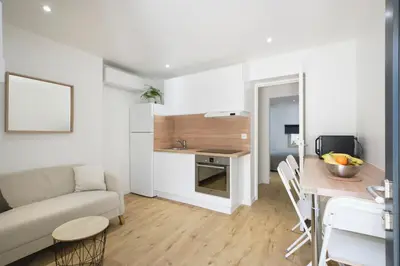 a living room and kitchen with a couch and a table at VILLA DES PERGOLAS -6 Bdrs - 5 bathrs -Parking -Jardin -JACUZZI -TRAMstation , 10 min beach in Nice