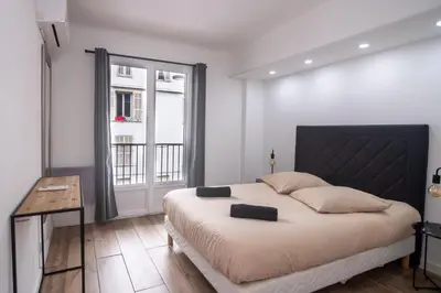 a bedroom with a large bed and a window at Bel appartement - Nice centre in Nice