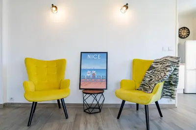 two yellow chairs and a picture on the wall at Confortable 2 pièces 54 m2 proche de la mer in Nice