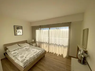 a bedroom with a bed and a large window at 2P Cagnes Sur Mer- Proximité Plage, Parking in Cagnes-sur-Mer