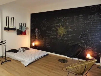 a bedroom with a chalkboard wall with a bed and chairs at Studio japonisant in Nice